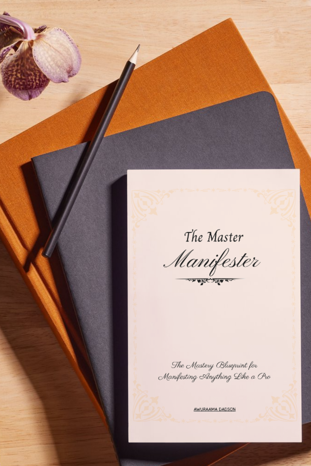 The Master Manifester book by Awuraama Dadson, styled on a desk with journals and orchids